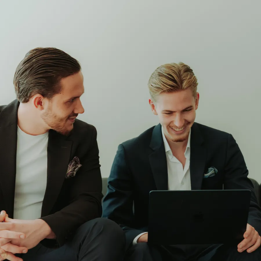 Zwei Kollegen auf der Couch am Laptop